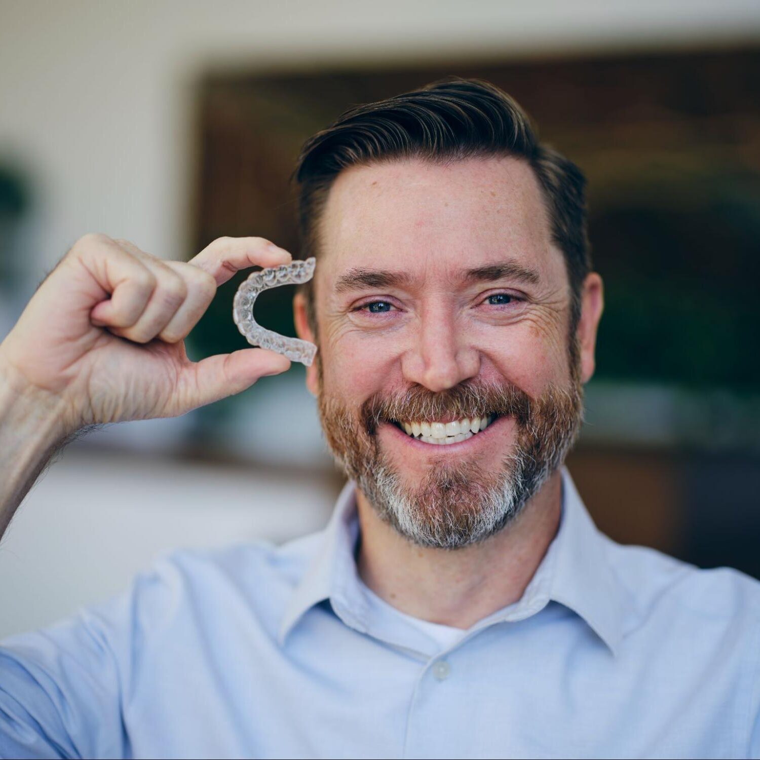 Patient holding clear aligners at an orthodontist office in Stephenville